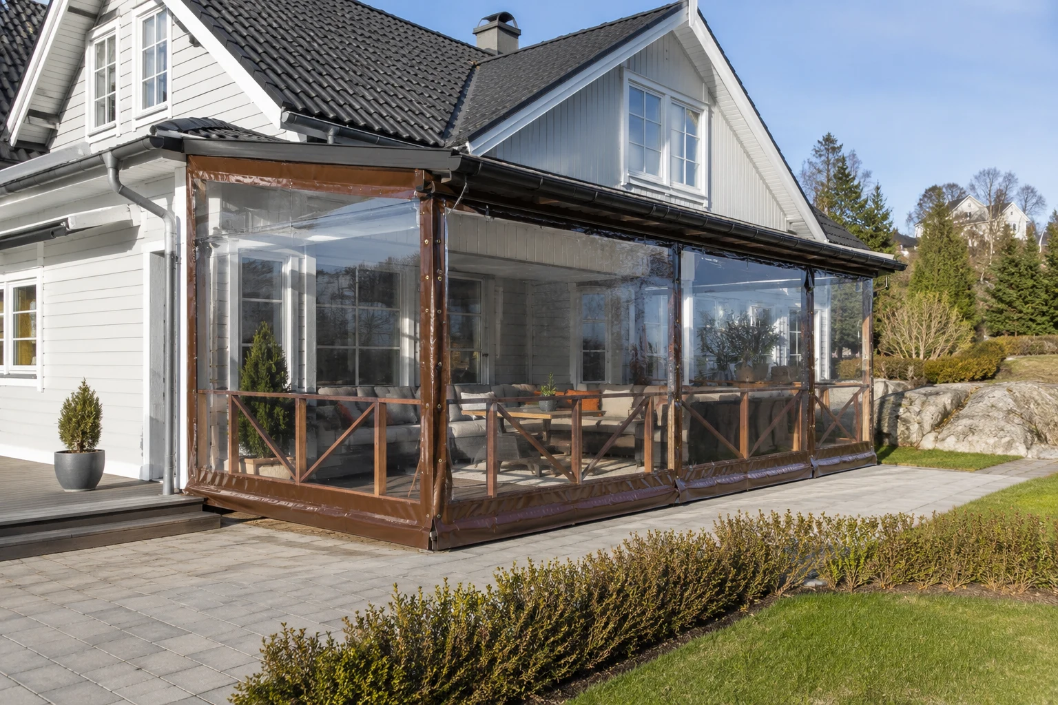Overbygget terrasse med transparent terrassevegg og brune kanter